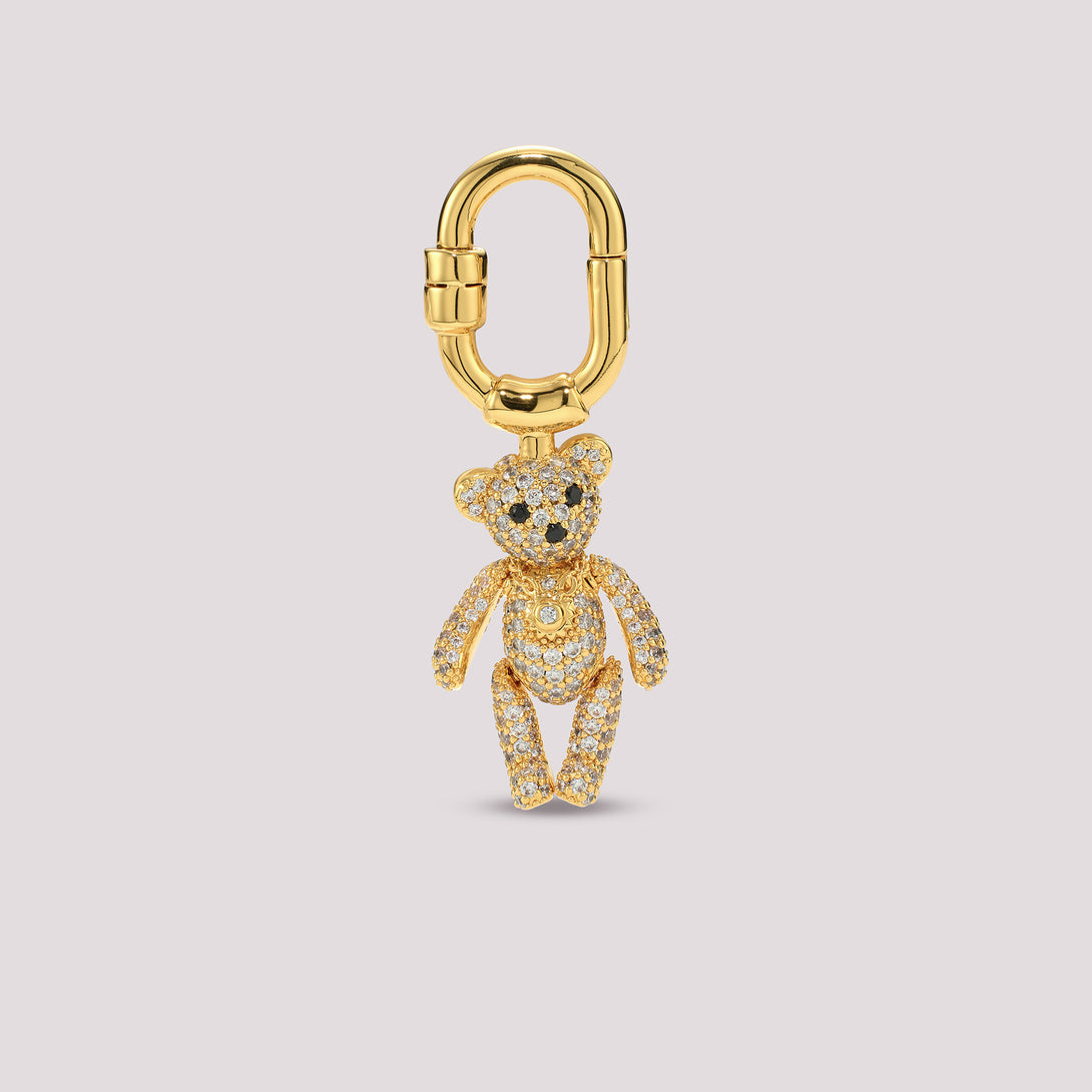 Gold Charmante teddy bear charm on a light gray background