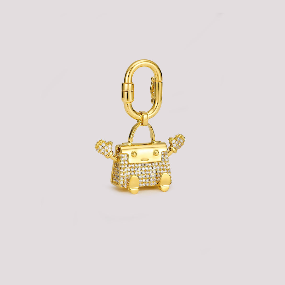 Kellydoll bag charm featuring playful waving arms and hand-set pavé stones, with doll-like legs and a miniature handbag design. A timeless luxury accessory, perfect for adding a unique touch to your Hermès collection or any high-end handbag.