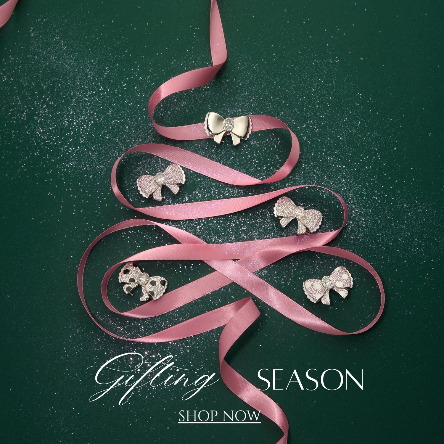Pink ribbon shaped like a Christmas tree with jewelry on a green background, promoting the 'Gifting Season'.