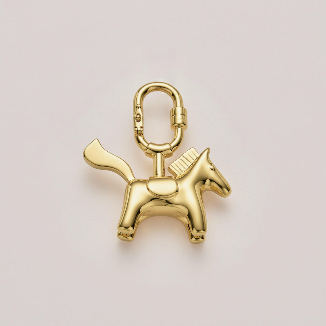Handcrafted pony bag charm with gold plating, perfect for Hermès and luxury handbags. A premium accessory designed to enhance high-end bag collections.
