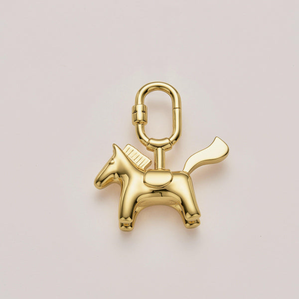 Handcrafted pony bag charm with gold plating, perfect for Hermès and luxury handbags. A premium accessory designed to enhance high-end bag collections.