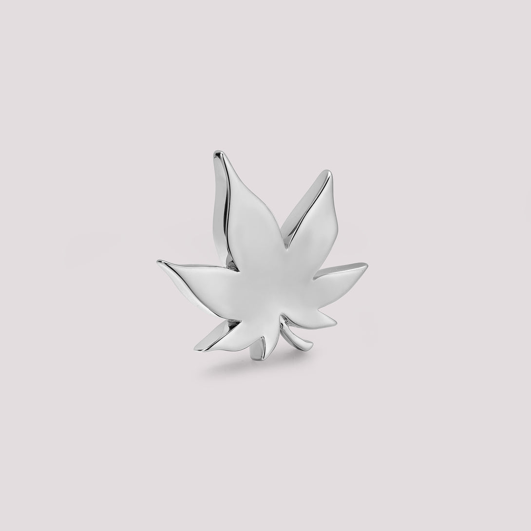 Silver cannabis leaf-shaped bag charm on a light gray background