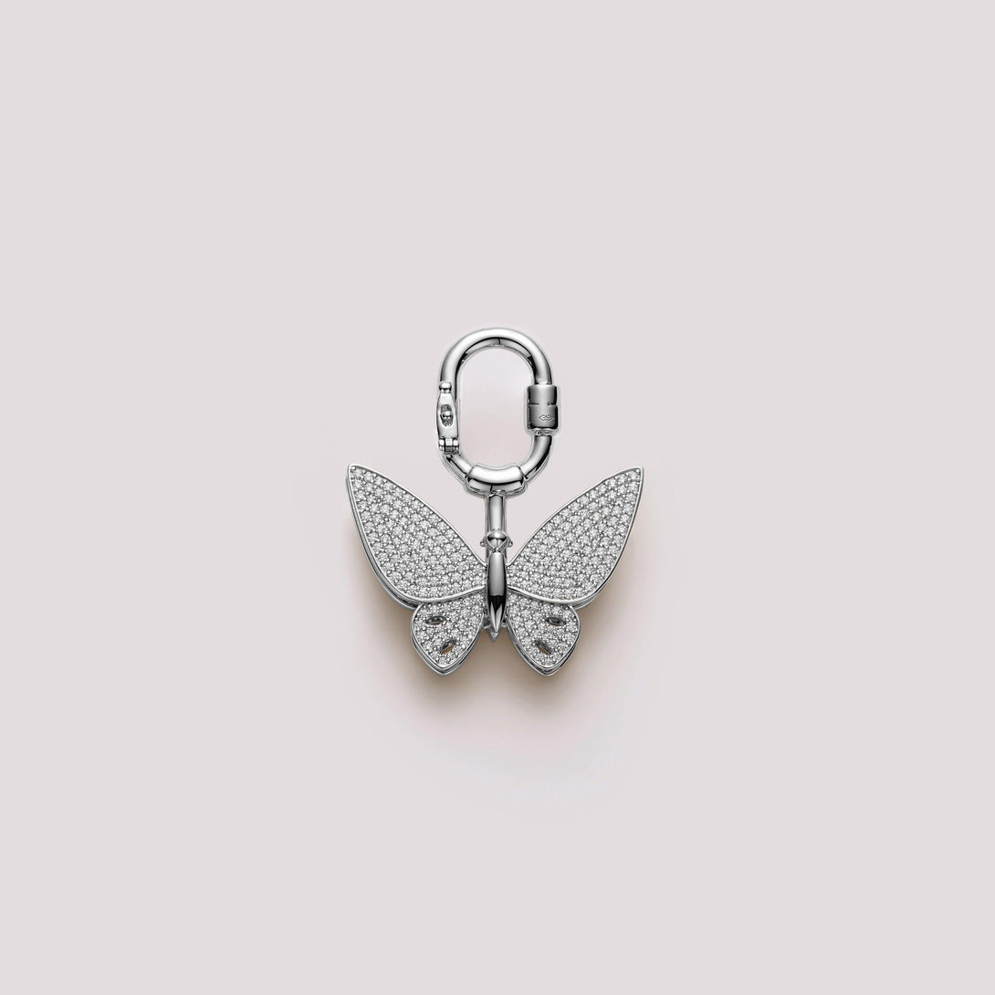 Luxury butterfly bag charm with pavé stone detailing, handcrafted for designer handbags like Hermès. Featuring a delicate silver finish, this charm adds elegance and sparkle to any luxury bag
